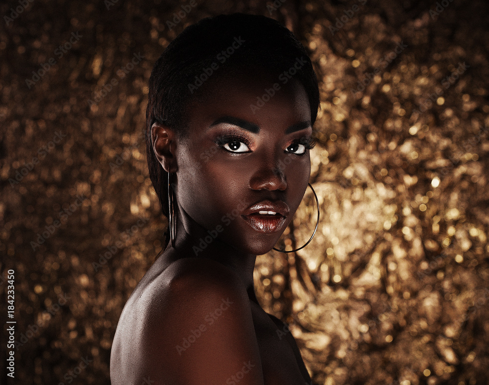portrait of sensual young african woman against golden background - obrazy, fototapety, plakaty 