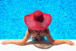 © Alex Pelikh - Beautiful european woman in red hat is relaxing in the swimming pool