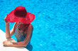 © Alex Pelikh - Beautiful european woman in red hat is relaxing in the swimming pool