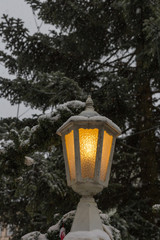 snowfall on christmas market with lights lamps and decoration in advent december 2