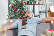 © weedezign - Asia man hangover and passed out sleep on sofa after heavy Christmas and new year party finish and lay on couch until morning,celebration holiday event.