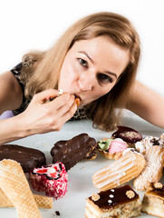 Young woman eating cupcakes with pleasure after a diet