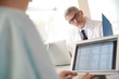 © goodluz - Mature doctor in office working on laptop computer