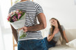 © LIGHTFIELD STUDIOS - cropped shot of young man hiding bouquet behind back to present it to girlfriend