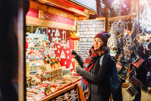 Woman Tourist Buys Souvenirs And Gifts At The Christmas Market In Prague