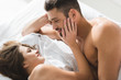 © LIGHTFIELD STUDIOS - high angle view of young couple relaxing together in bed in morning