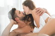 beautiful young couple kissing in bed at sunny morning