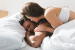 © LIGHTFIELD STUDIOS - beautiful young woman lying on her sleeping boyfriend in morning