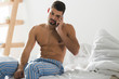 © LIGHTFIELD STUDIOS - handsome young man talking by phone in bed