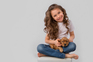 Kids pet friendship concept - little girl with red puppy isolated on white background