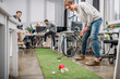 happy people playing in mini golf at modern office