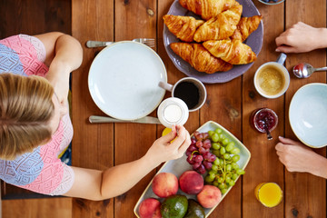 woman with cream and coffee having breakfast