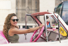 Beautiful Woman Tourist Driving A Classic Car In Cuba.