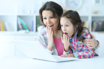 mother and daughter using laptop