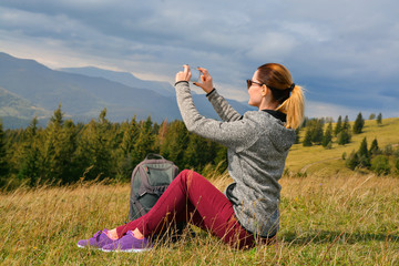 Canvas Print - Female tourist taking photo of beautiful mountain landscape