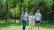 © allensima - Chinese family smiling & walking together in park