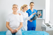 © zinkevych - Doctors at work. Smart nice female doctor pointing the X ray photo and talking to her colleague while holing patients shoulder