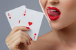 © blackday - Woman with red lips is holding two aces.