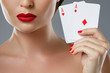 © blackday - Woman with red lips is holding two aces.