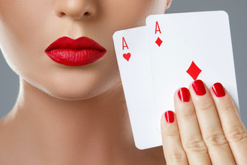 Wall Mural - Woman with red lips is holding two aces.