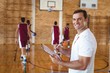 © WavebreakMediaMicro - Basketball coach holding clipboard in the court