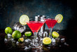 Red cosmopolitan cocktail with lime in martini glass, on dark rusty background copy space