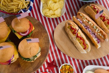 Wall Mural - Hot dogs and burgers on wooden table with 4th july theme