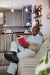© wavebreak3 - Senior man reading book while sitting on sofa