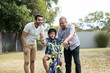 © wavebreak3 - Father and grandfather assisting boy for riding bicycle