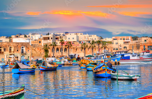 Plakat Port Marsaxlokk na Malcie, oświetlony światłem zachodzącym słońca, europejska podróż w pięknym miejscu