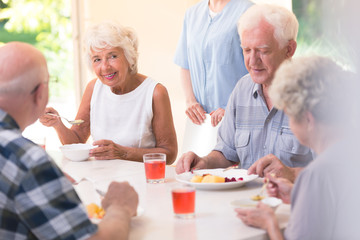 Poster - Smiling senior woman eating soup