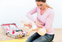 Woman In First Aid Course Practicing Revival Of Infant On Baby Doll
