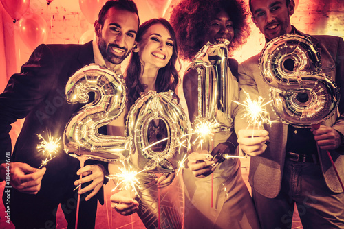Party people women and men celebrating new years eve 2018 with sparklers and Cha Poster