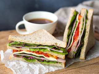 Homemade ham cheese sandwich with fresh tomato and lettuce for breakfast.