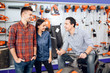 © VadimGuzhva - A consultant in a garden tools store shows a customer a lawn mower.