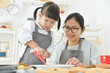 © eggeeggjiew - Asian Kid and young mother decorating cookies.