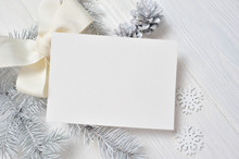 Mockup Christmas Greeting Card With White Tree And Cone, Flatlay On A White Wooden Background, With Place For Your Text