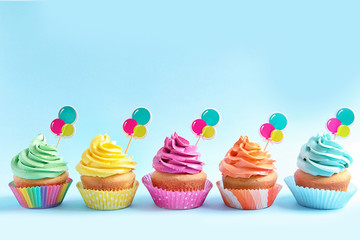 Wall Mural - Delicious cupcakes on color background