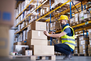 Poster - Male warehouse worker with barcode scanner.