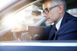 © goodluz - Portrait of businessman driving car for work