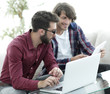 © ASDF - Portrait of two web designers discussing a project in front of a laptop