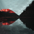 Sonnenuntergang in den Bergen mit Alpenglühen und glatter Reflektion in einem See