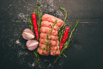 Raw meat Beef fillet with rosemary and spices on a black wooden background. Top view. Free space for text