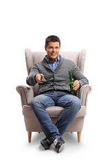 Sticker - Young guy with a remote control and a beer bottle seated in an armchair