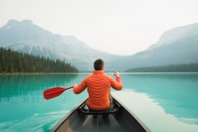 Rear View Of Man Kayaking In Lake