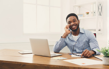 Wall Mural - Young black businessman talking on mobile phone