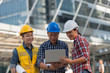 © xreflex - Asian engineers group consult construction on site building working while holding laptop and blueprint paper. in city background. teamwork concept.