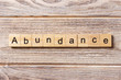© sosiukin - abundance word written on wood block. abundance text on table, concept