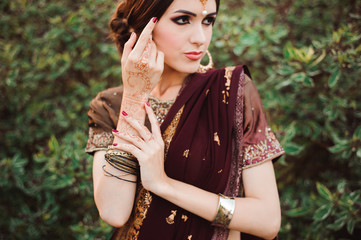 Mehendi on the hands of girls, Woman Hands with brown mehndi tattoo. Hands of Indian bride girl with brown henna tattoos.