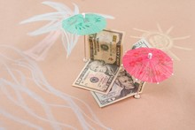 The Concept Of Offshore Banking And Tax Havens. Picture With Dollar Bills On A Tropical Beach, Under A Palm Tree And An Umbrella